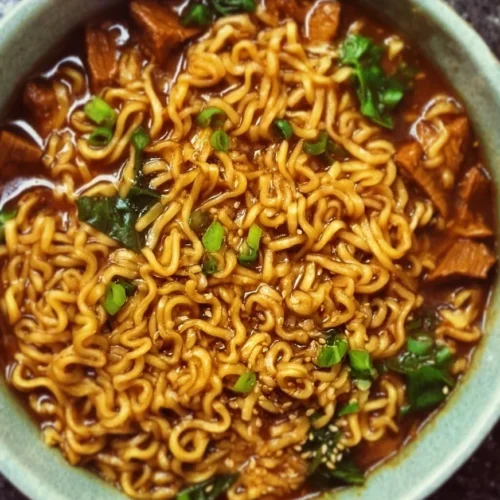 Easy Saucy Ramen Noodles 2 Delicious bowl of easy saucy ramen noodles garnished with green onions and sesame seeds.