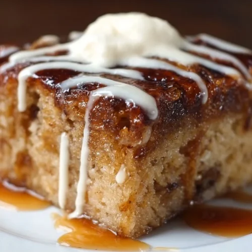 Sticky banana bread pudding cake topped with caramel sauce and bananas