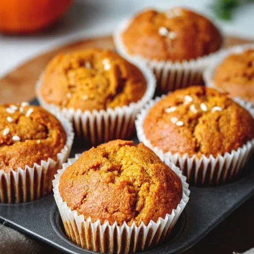 Wholesome Pumpkin Protein Muffins 2 Wholesome pumpkin protein muffins topped with nuts and spices.