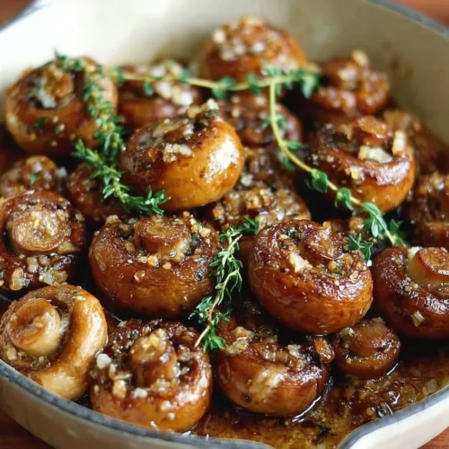 Roasted mushrooms with browned butter, garlic, and thyme on a white plate