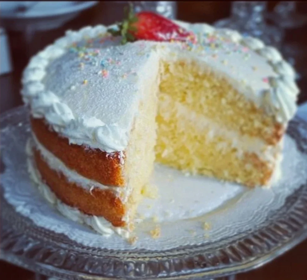 Vanilla Dream Cake 1 A slice of Vanilla Dream Cake topped with creamy frosting and fresh berries