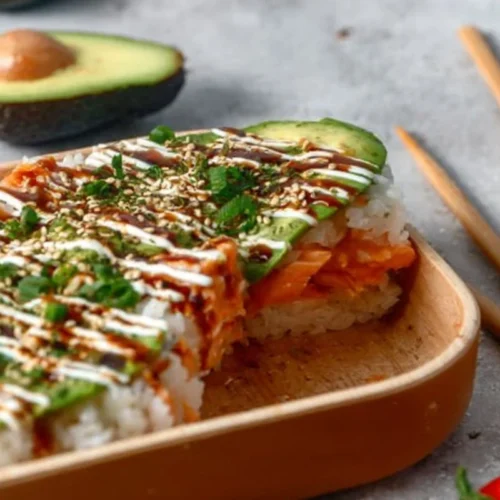 Ultimate Salmon Sushi Bake 2 Delicious salmon sushi bake dish topped with creamy sauce and garnished with scallions.