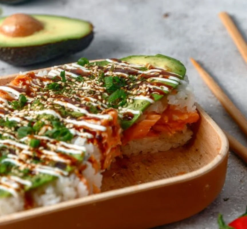 Ultimate Salmon Sushi Bake 1 Delicious salmon sushi bake dish topped with creamy sauce and garnished with scallions.