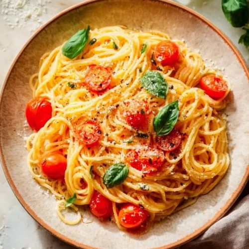 Classic Cheesy Tomato Garlic Pasta 2 Classic Cheesy Tomato Garlic Pasta served in a bowl with herbs and cheese garnish.
