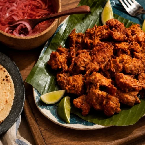 Delicious Cochinita Pibil served with pickled onions and tortillas